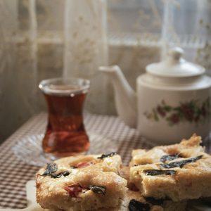 Cozy indoor tea setting with focaccia bread and a floral teapot, perfect for a warm, relaxing afternoon.